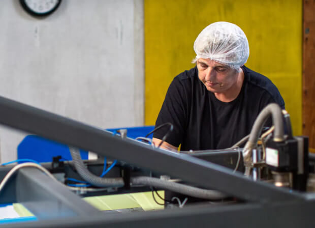 Man in a hairnet creating boxes for seafood packaging
